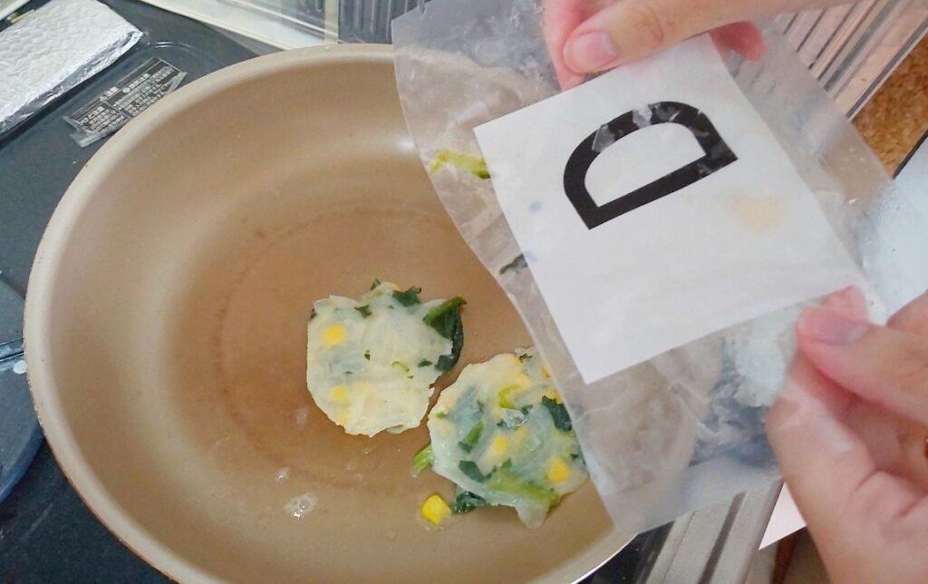 副菜のパウチをフライパンに入れる